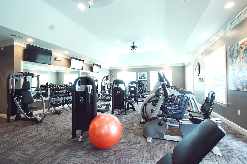 a gym with cardio machines and weights and a bowling ball