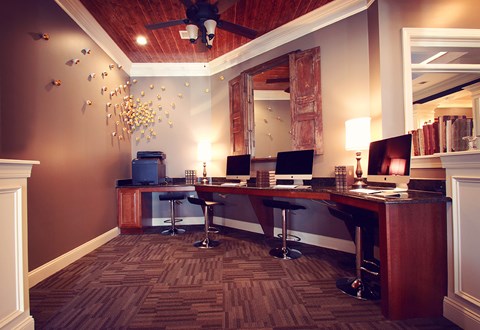 a desk with two computers and a mirror in a room