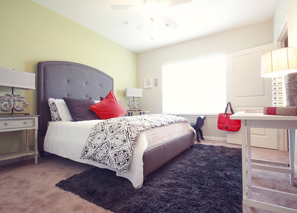 a bedroom with a bed and a desk and a window