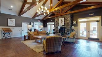 a large living room with a stone fireplace and wood floors