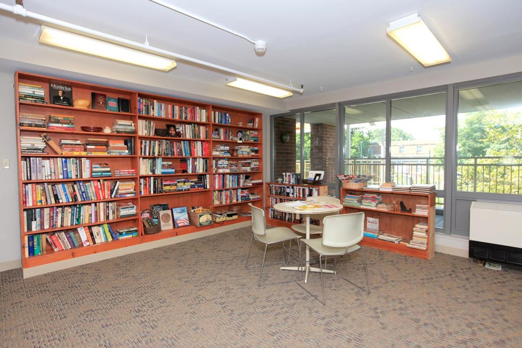 a library with bookshelves and a table and chairs