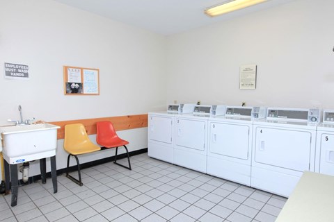 a washer and dryer room with a table and chairs and washing machines