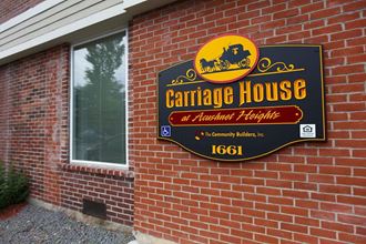 a sign for a carriage house on the side of a brick building