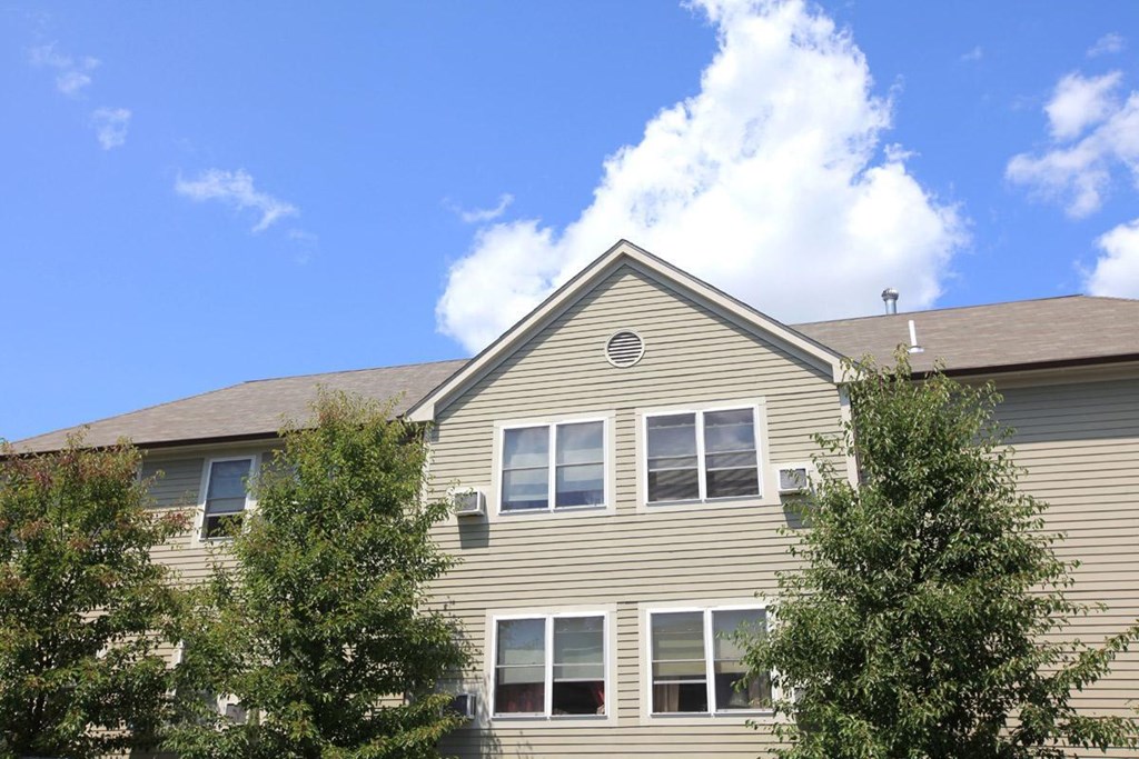 the front of a house with trees in front of it