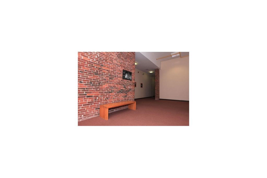 a room with a bench and a brick wall