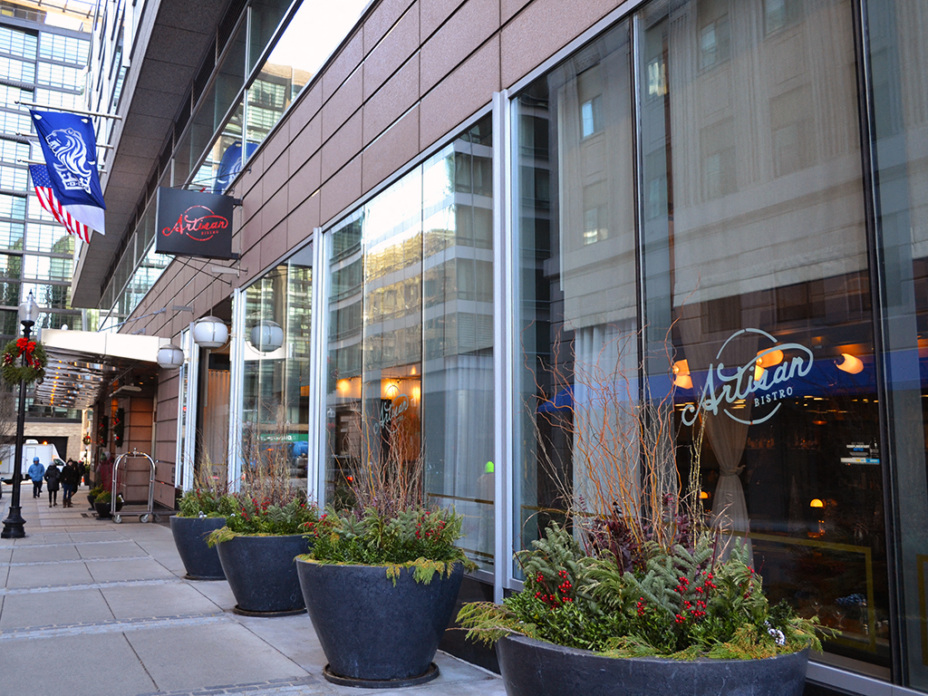 a sidewalk in front of a building with potted plants