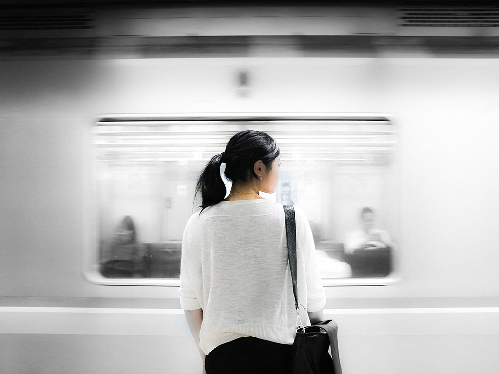 a woman standing in front of a subway train