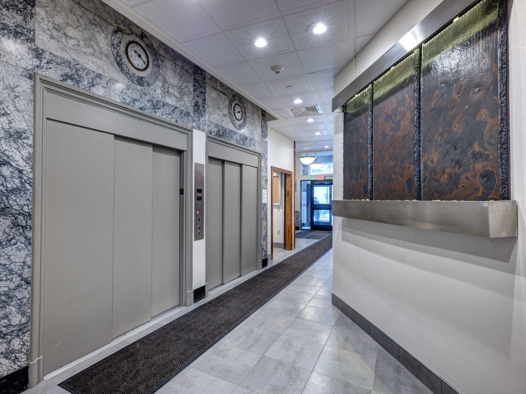 a hallway with white doors and a wall with a tapestry