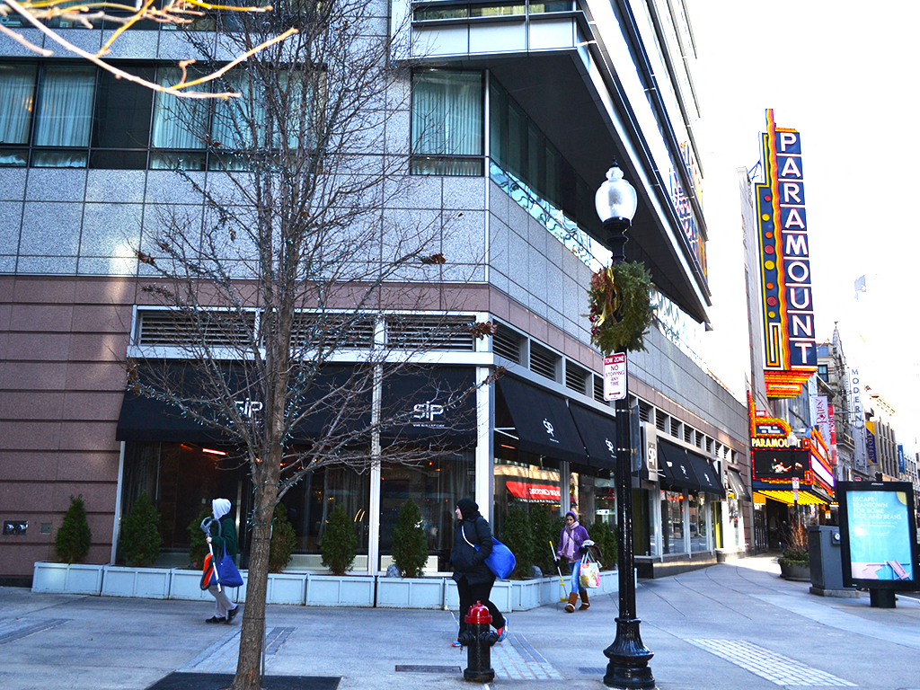 a city street with people walking in front of a building