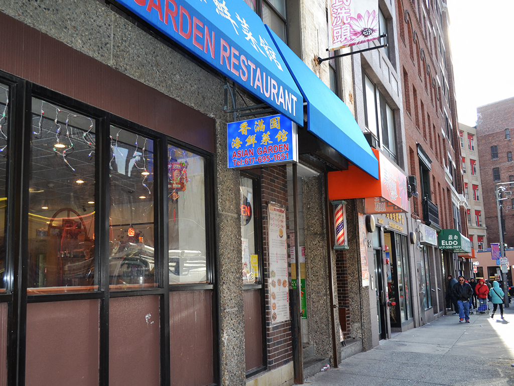 a restaurant with a blue sign on the side of a street