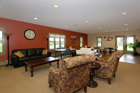 a living room with couches and chairs and a clock on the wall