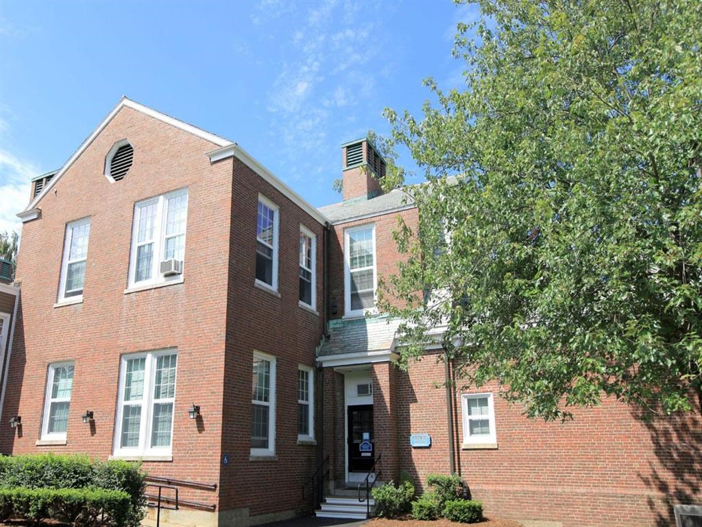a red brick house with a tree in front of it