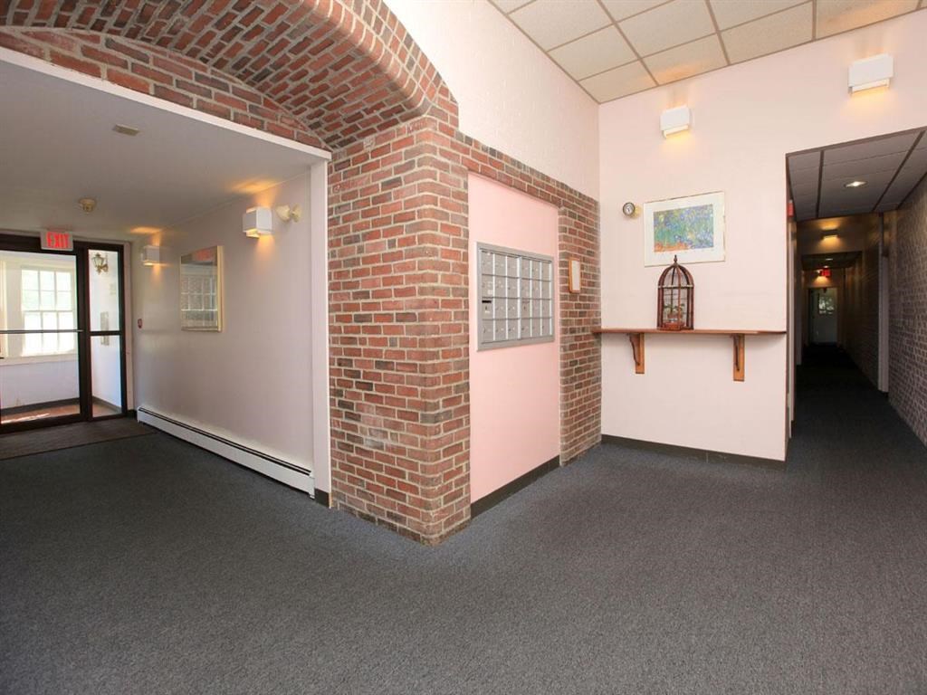 the hallway of a building with a brick wall and a door