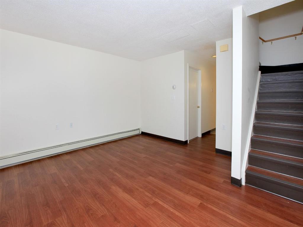 a living room with a hard wood floor and stairs