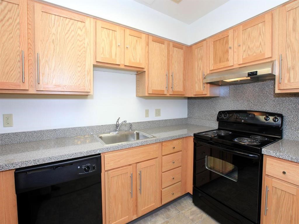 a kitchen with black appliances and wooden cabinets