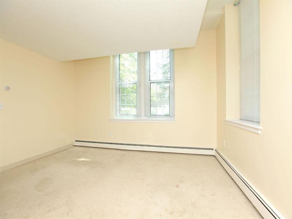 an empty room with two windows in it