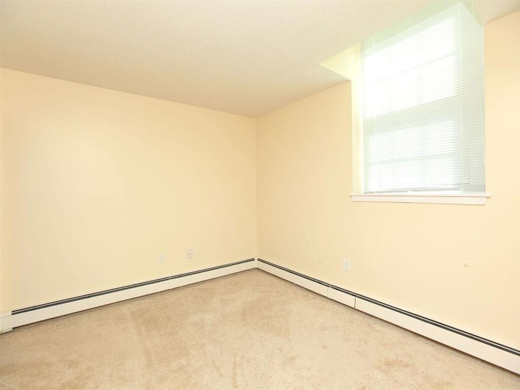 an empty room with white walls and a window
