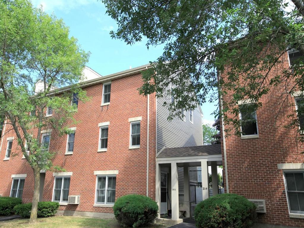 an apartment building with a brick facade and a porch
