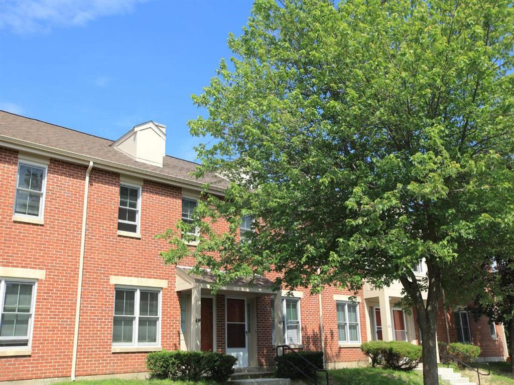 a brick house with a tree in front of it