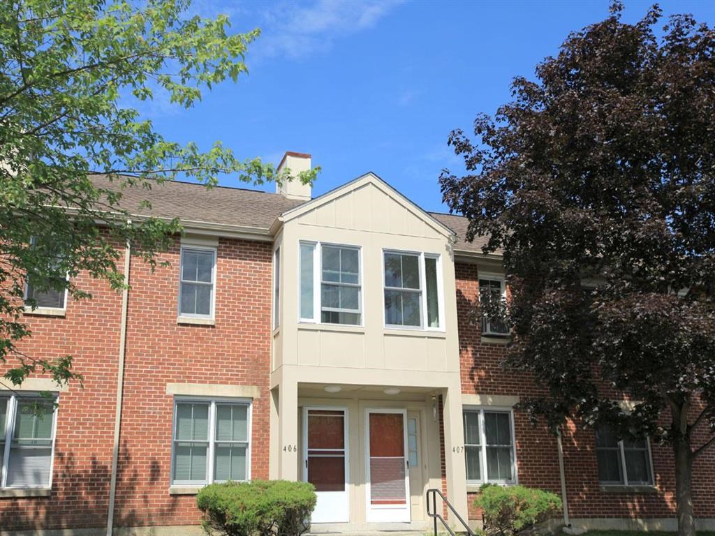 an apartment building with a red brick facade and a porch