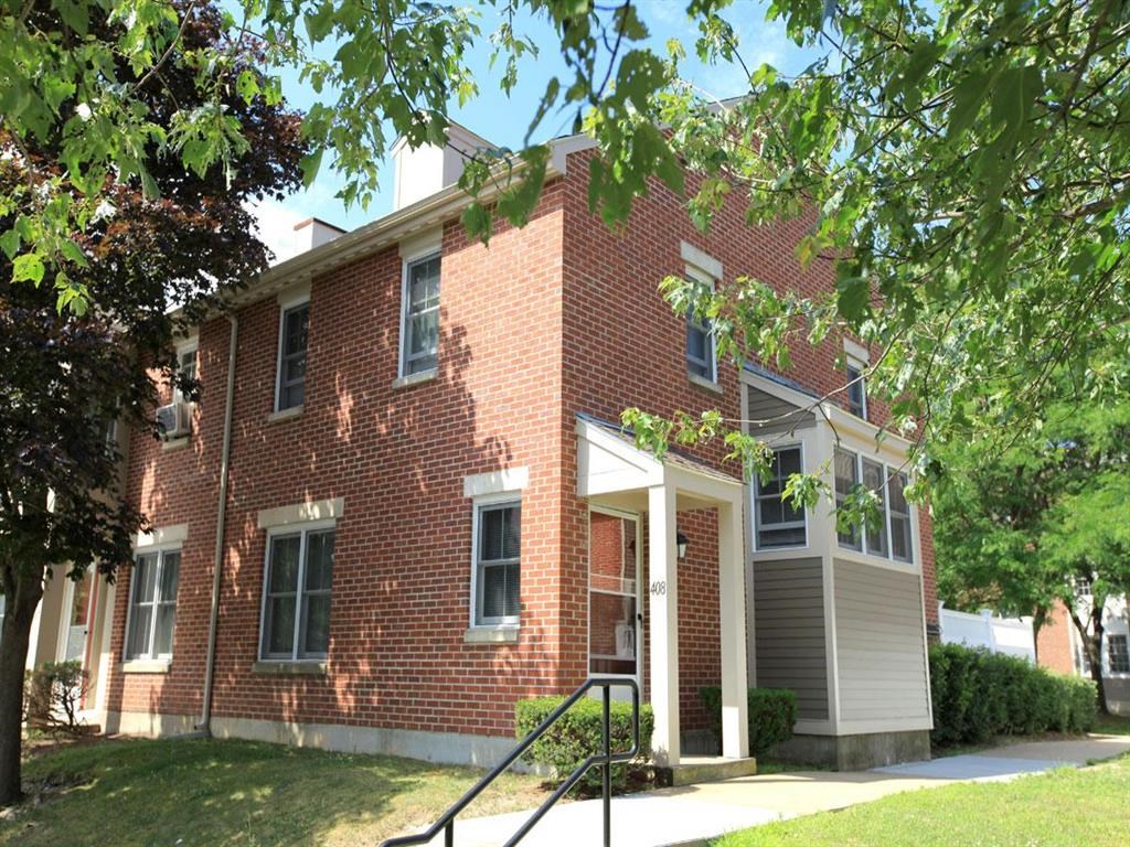 a red brick building with a tree in front of it