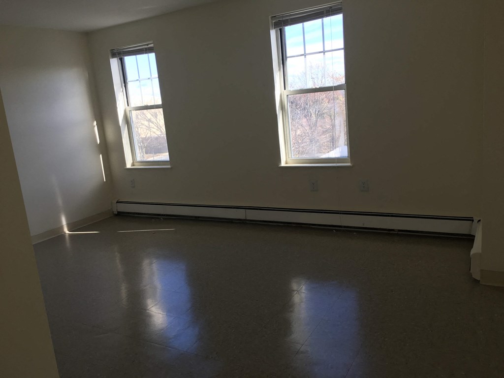 an empty room with two windows in it
