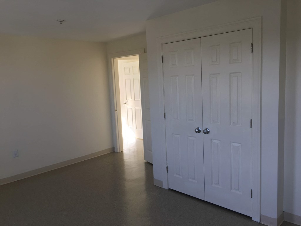 a bedroom with two closets and a door to a hallway