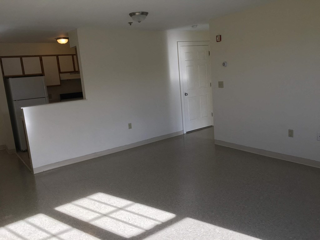 an empty living room with white walls and a white door