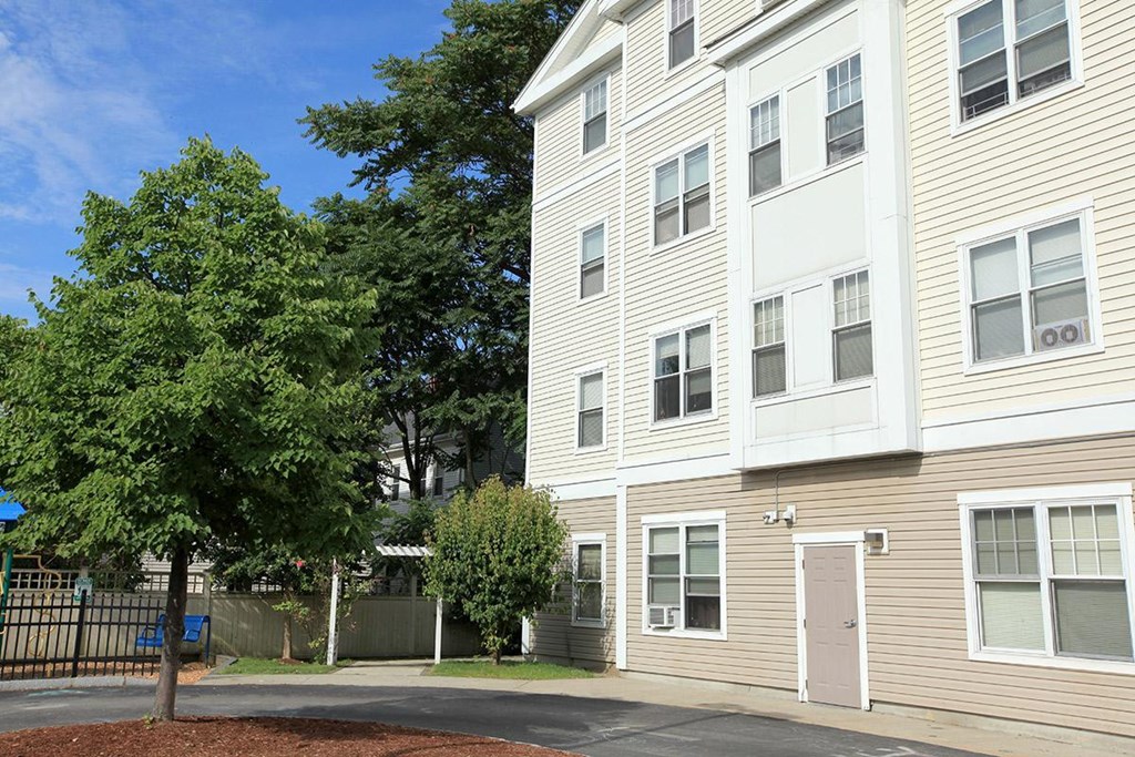 a white apartment building with a tree in front of it
