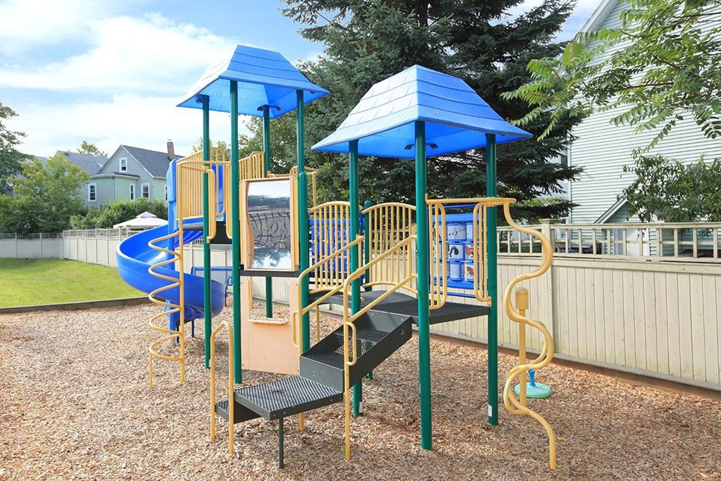 a playground with a blue and yellow swing set