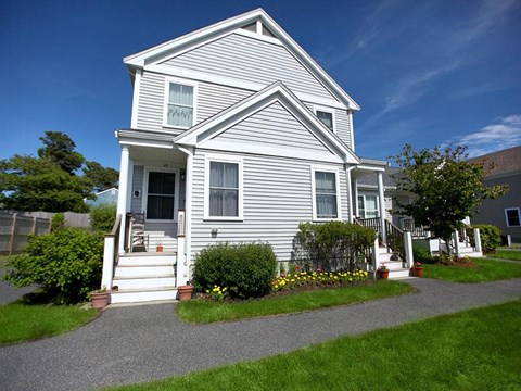a white house with a sidewalk in front of it