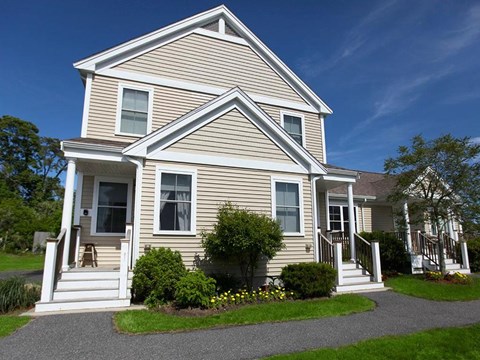 a yellow house with a driveway in front of it