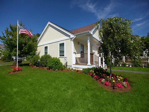 a white house with an flag in the front yard