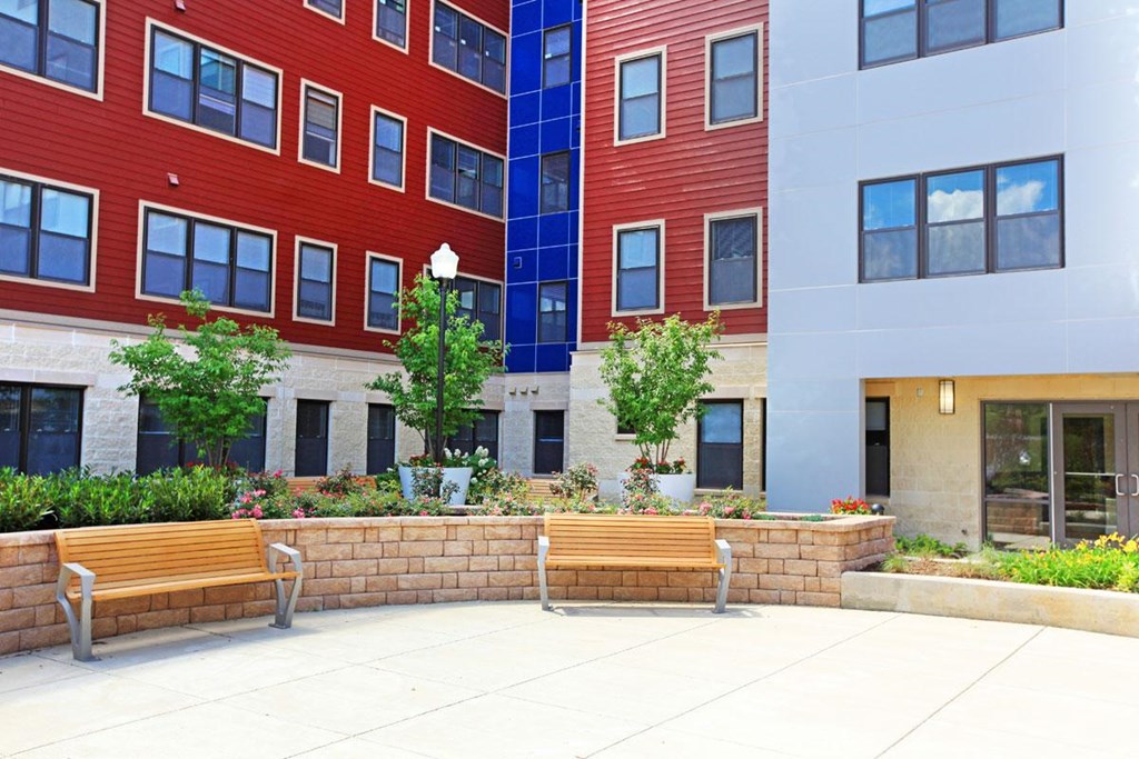 a courtyard with benches in front of a building