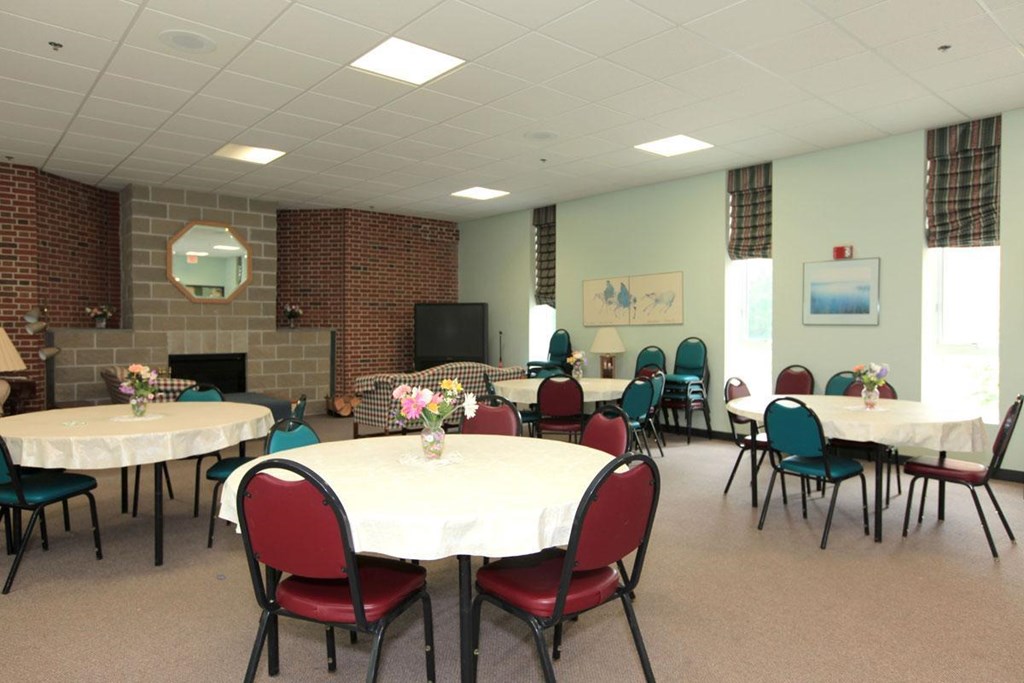 a dining room with tables and chairs and a fireplace