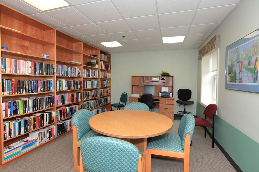 a library with a table and chairs and shelves of books