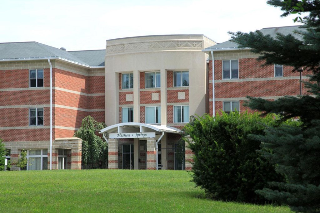 a large brick building with a lawn in front of it