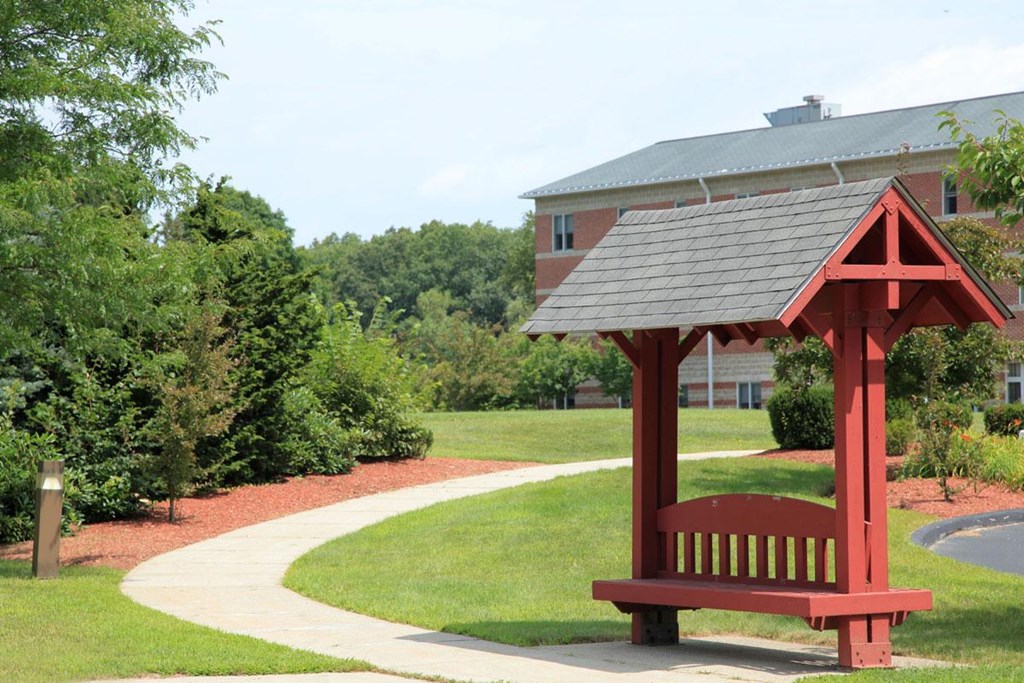 a red park bench sitting in front of a building