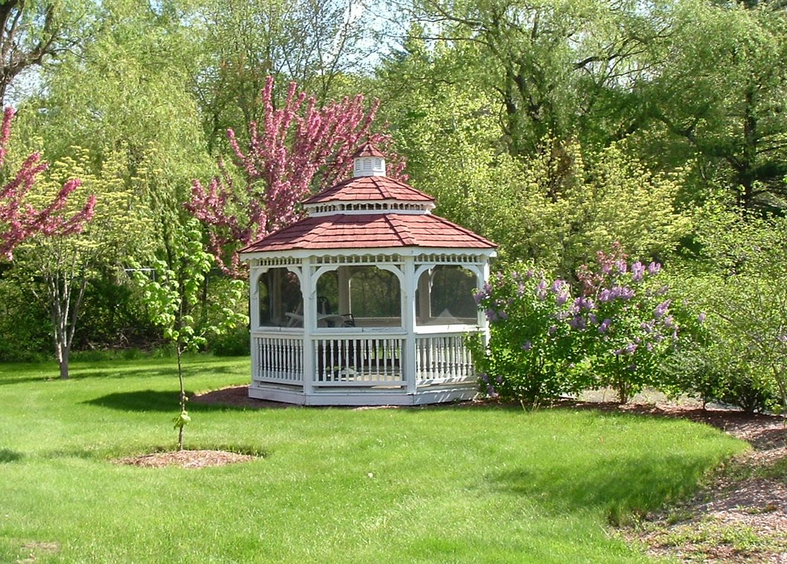 a white gazebo in the middle of a garden