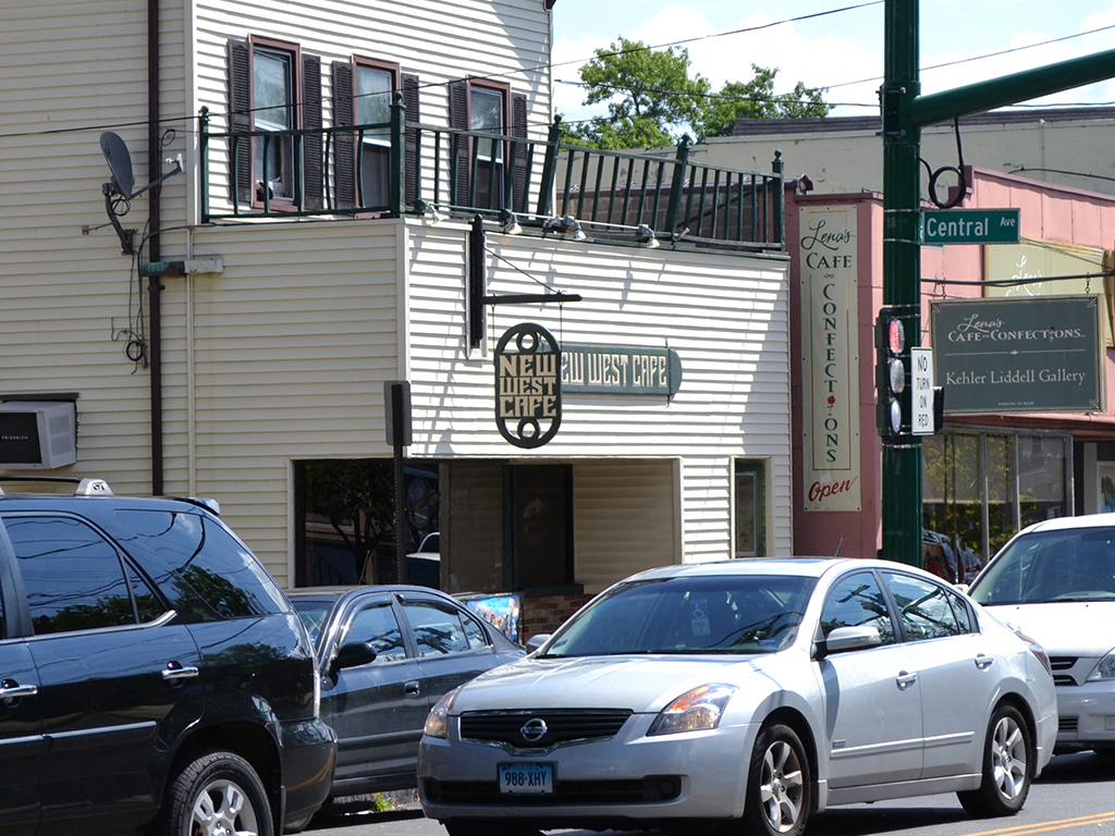 a city street with cars parked in front of a white building