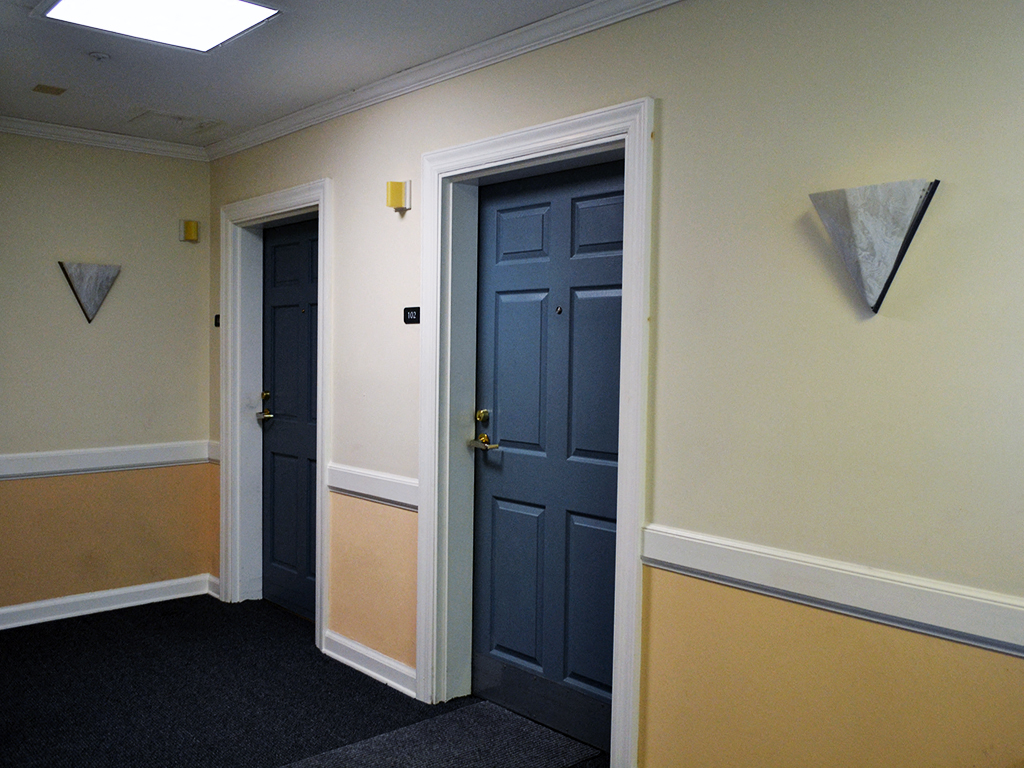 a hallway with two doors and a yellow wall with blue doors