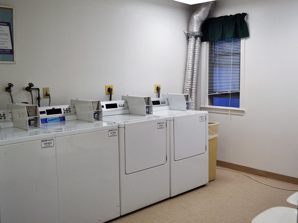 four washers and dryers in a room with a window
