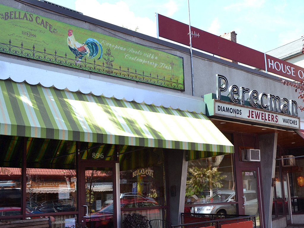 the front of a restaurant with a green and white awning