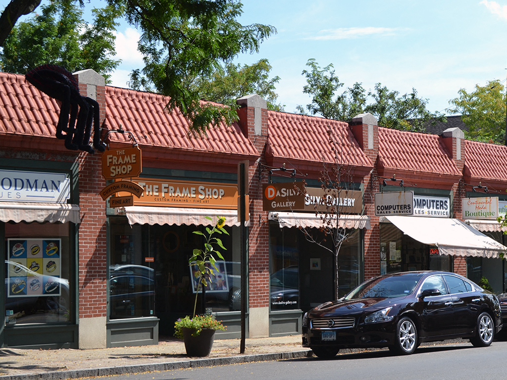 a car parked in front of a store with a red brick building