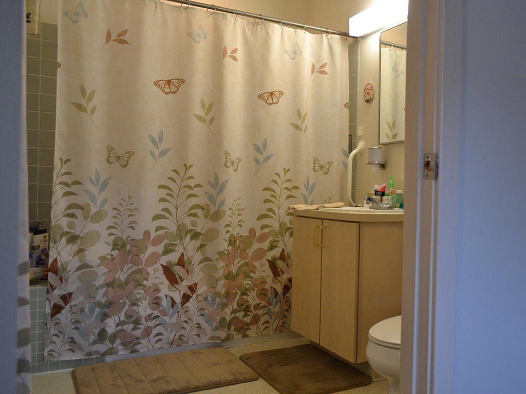 a bathroom with a shower curtain and a sink and a toilet