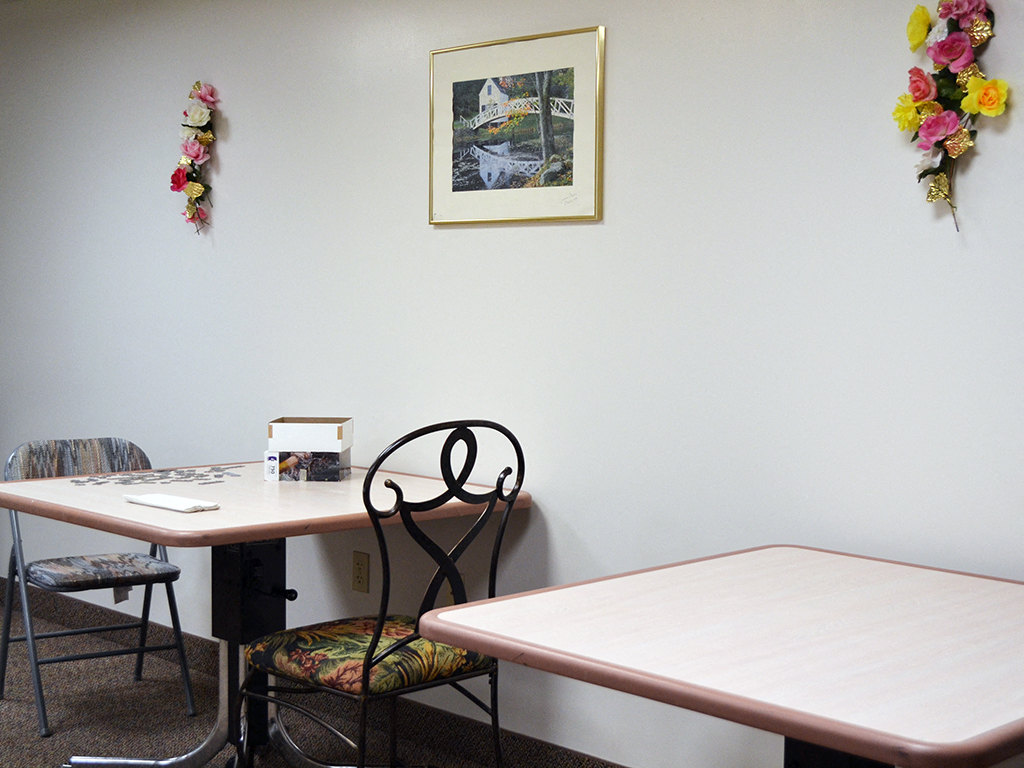 a dining room with a table and chairs and a picture on the wall