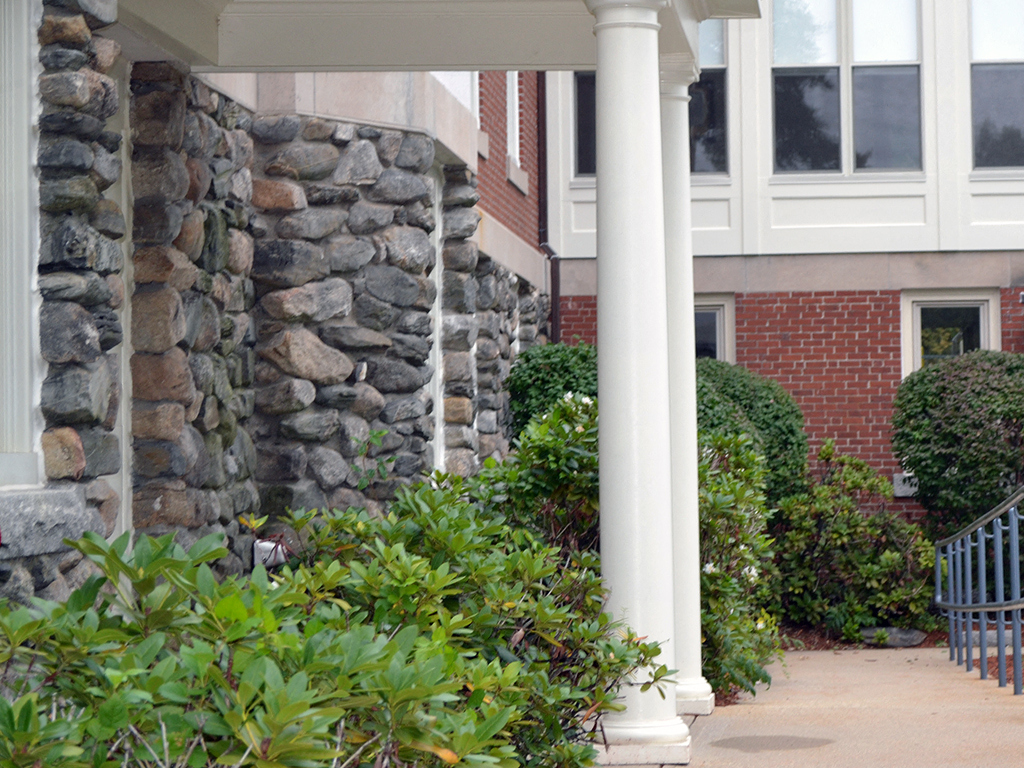 a covered walkway in front of a building with columns