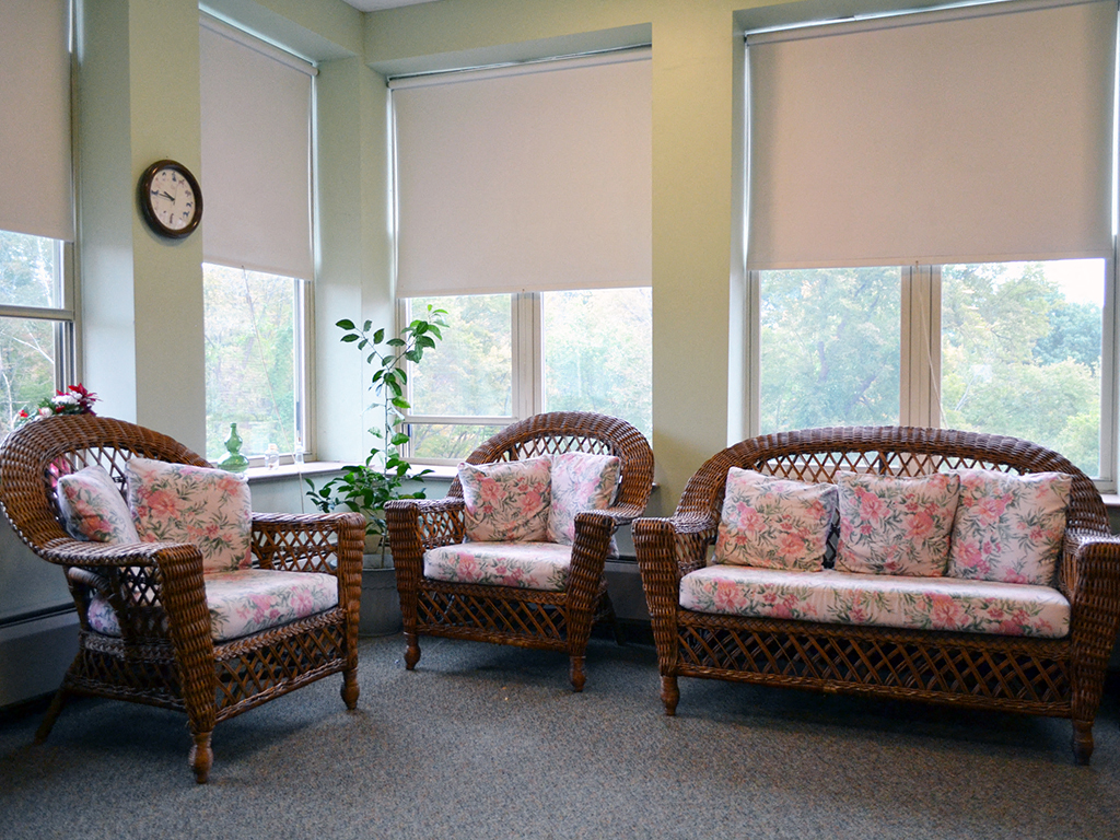 three chairs in a room with windows and a clock on the wall