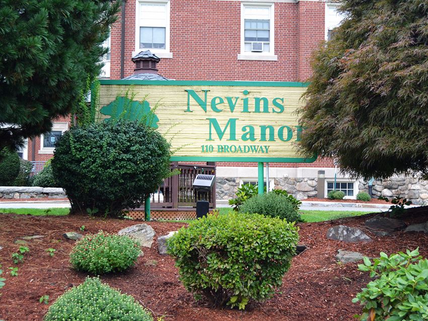 a building with a sign in front of a garden
