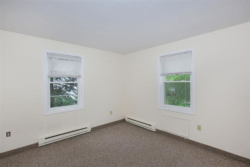 an empty room with two windows in it
